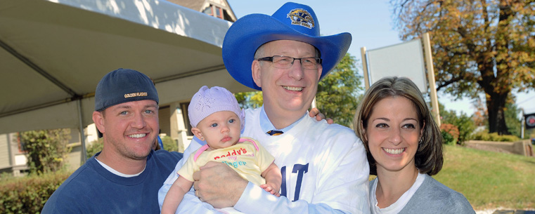 <p>President Lester A. Lefton poses for a photo with Kent State alumni along the Homecoming parade route.</p>