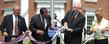 Dr. Stephen Berlin, former chair of the board of the Ohio College of Podiatric Medicine, Dr. Thomas Melillo, CEO of the College of Podiatric Medicine, Dr. Lester Lefton, President of Kent State University and Jacqueline Woods, Chairperson of the Kent State board of trustees, tie a ribbon signifying the joining of Kent State University and the Ohio College of Podiatric Medicine.