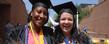 Two graduates pose for photos near the MAC Center following morning commencement ceremonies.