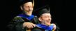 A doctoral degree recipient, right, reacts while being hooded during the advanced degree ceremony in the Memorial Athletic and Convocation Center. <br />
<br />