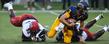 <p>Kent State's quarterback twists through a pair of Louisiana defenders.</p>