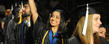 A summer 2011 graduate from the College of Arts and Sciences waves to her family during commencement.