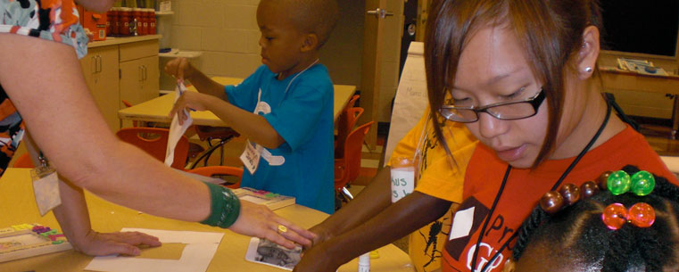 A Kent State student reads a story to kindergarten children in the Bridges to Kindergarten program. Bridges to Kindergarten is expanding from a two-week summer camp to year-round literacy support at Rankin, Crouse and Schumacher public schools in Akron, Ohio.&nbsp; (Photo courtesy of Janice Kroeger, Kent State University.)<br />