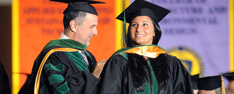 Kent State College of Podiatric Medicine student Christina Schilero is hooded by her father, Dr. John Schilero, during the college’s commencement ceremony.