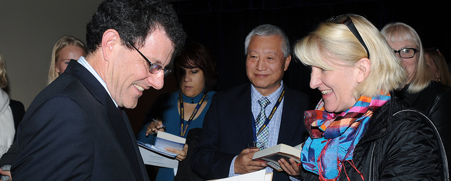 Pulitzer Prize-winning journalist Nicholas Kristof autographs copies of "Half the Sky," the book he co-authored with his wife, Sheryl WuDunn, the first Asian-American to win the Pulitzer Prize.