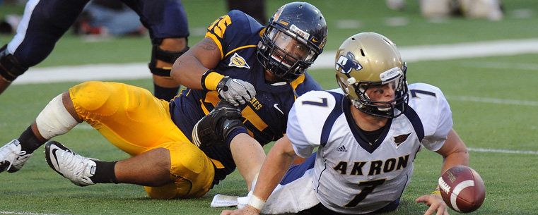 <p>A Kent State defensive lineman strips the ball from the Akron Zips quarterback in the end zone, resulting in a Kent State touchdown, ensuring a 28-17 victory during the Homecoming game at Dix Stadium.</p>