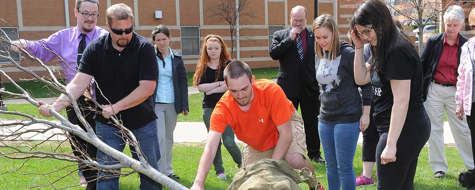 Kent State students and employees work together to plant a tree during the annual Arbor Day celebration near the Centennial Court residence halls.