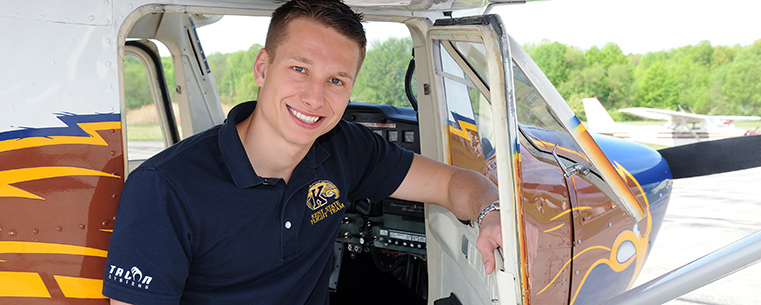 Kent State aeronautics student Ryan Weber works in and around the fleet of Kent State planes at the Andrew Paton Field in Stow, Ohio.