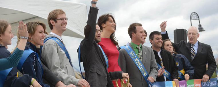 Kent State President Lester A. Lefton (far right) joins Evan Gildenblatt (center holding the ceremonial ribbon-cutting scissors), executive director of Kent State's Undergraduate Student Government, and members of the Homecoming Court in celebrating the university's new Student Green at a ribbon-cutting ceremony.