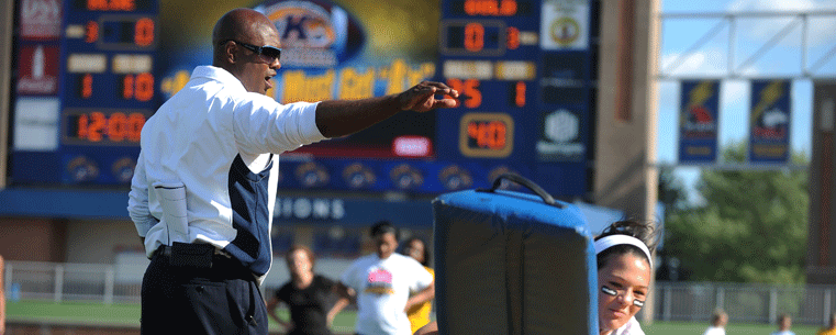 Kent State Golden Flashes head football coach Darrell Hazell works with participants during a recent woman's football clinic at Dix Stadium.