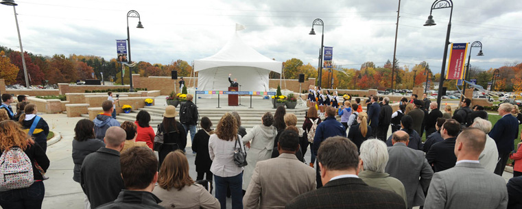 A crowd watches as Kent State President Lester A. Lefton speaks during the ribbon-cutting ceremony for the new Student Green.