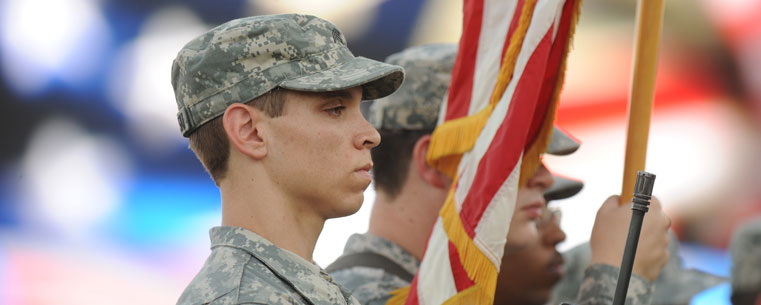 A member of the Kent State Army ROTC stands at attention during the playing of the National Anthem at a home football game.