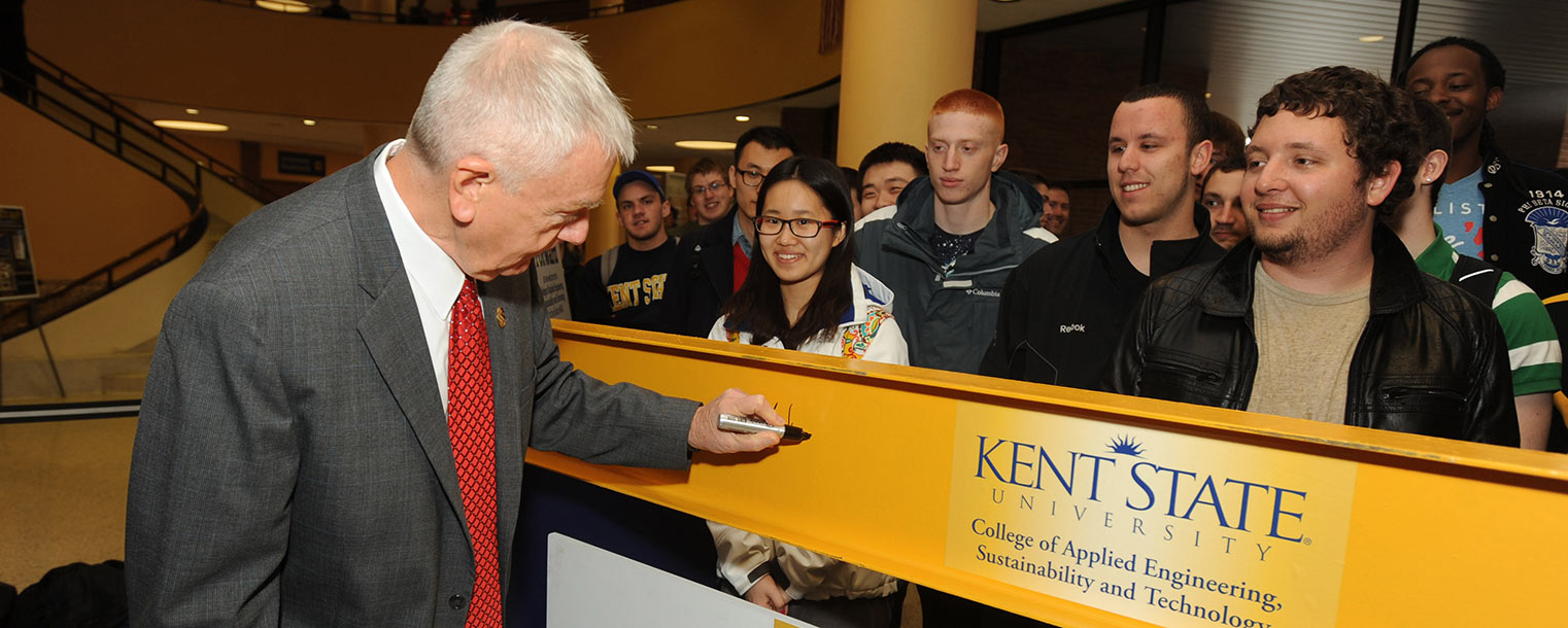 Robert G. Sines Jr., interim dean of Kent State’s College of Applied Engineering, Sustainability and Technology, signs the I-beam that will be installed in the college’s new building.