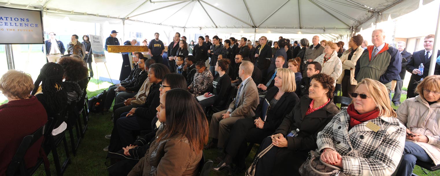 A crowd gathered under a tent listens to a few words by Robert Sines, interim dean of Kent State's College of Applied Engineering, Sustainability and Technology.