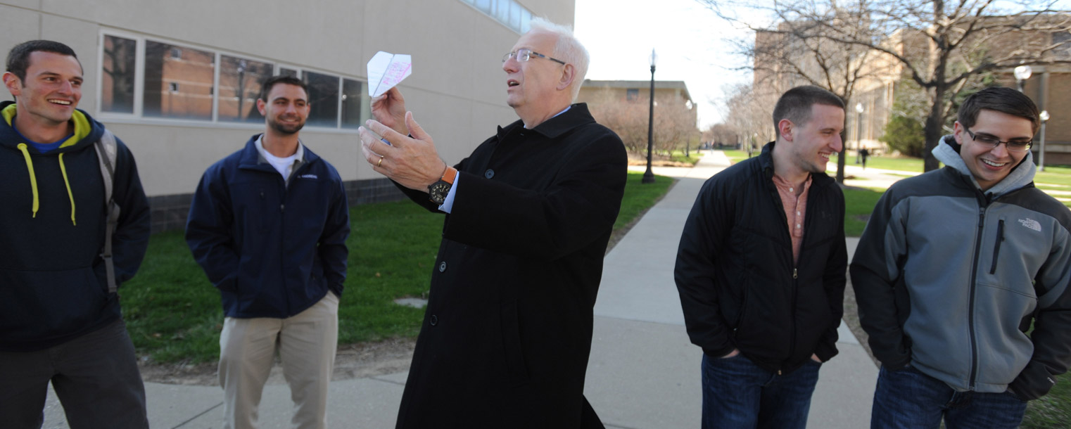 Kent State President Lester A. Lefton throws a paper airplane with aeronautics students who were raising money for charity.
