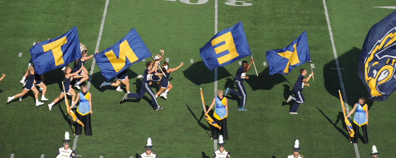 The Kent State cheerleaders lead the team onto the field.