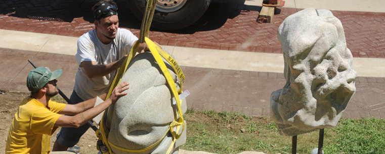 Assistants to Cleveland artist Giancarlo Calicchia install the sculpture "Athleta" near Kent Hall.