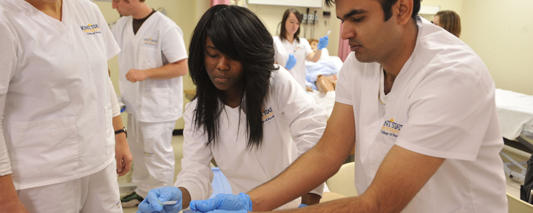 Students in Kent State's College of Nursing practice inserting a catheter into a simulated patient during class.