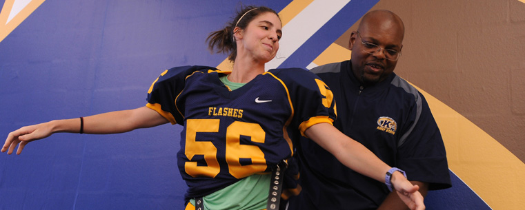 <p>Clifton Ragin Jr., head equipment manager for Kent State Golden Flashes football team, shows the proper way to wear shoulder pads during the Women’s Football Clinic.<br />
</p>