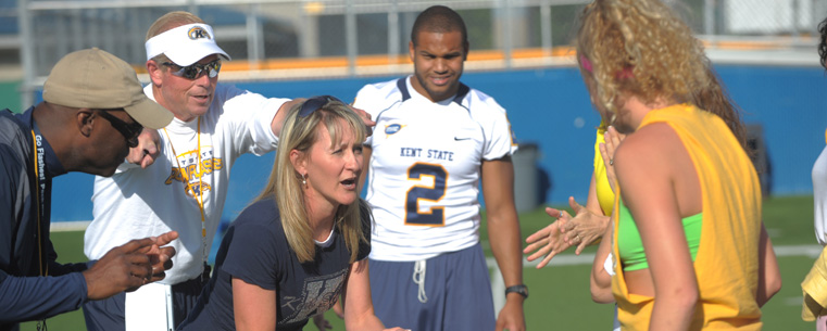 <p>Assistant coaches for the Kent State Golden Flashes drill one of the women on making calls before a play.</p>