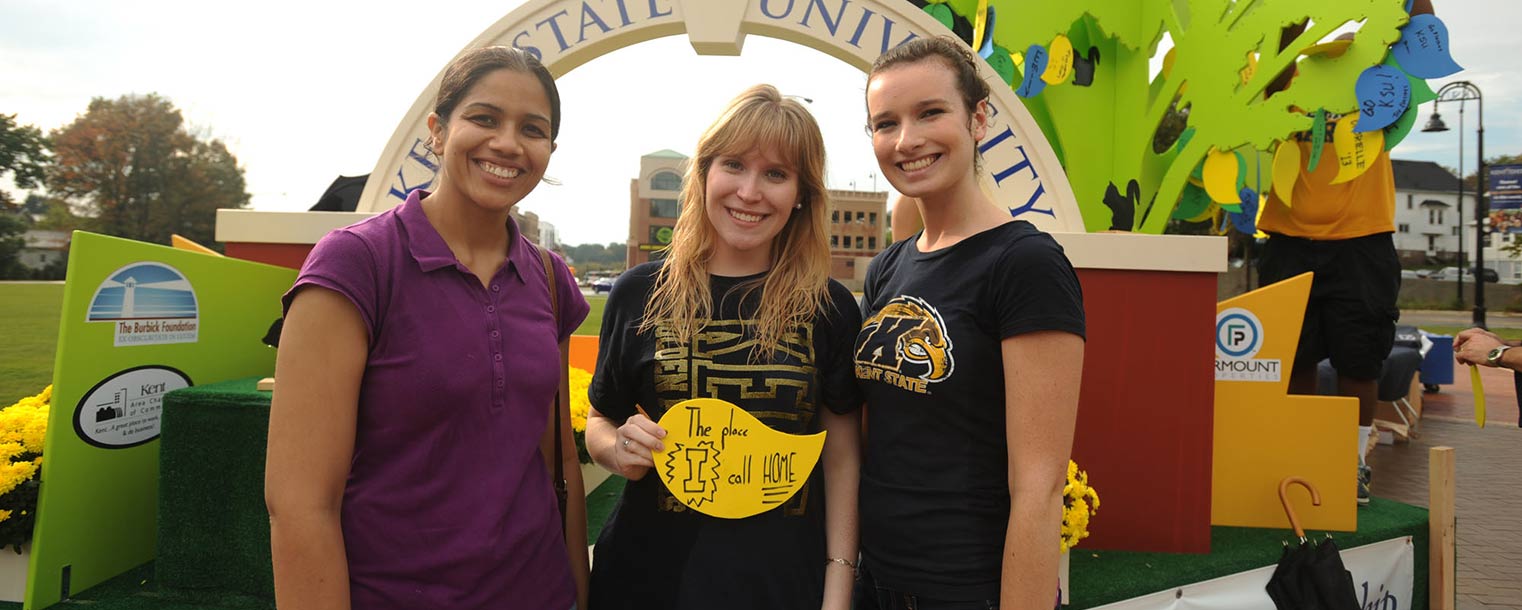 Kent State students hand out leaves to be added to a Homecoming float.