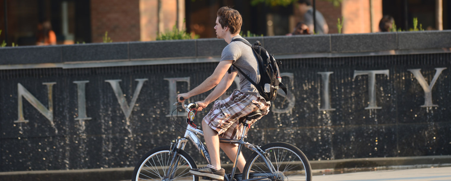 A Kent State student rides by the fountain in Risman Plaza.