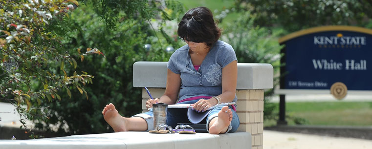 A Kent State University student studies near White Hall, home of the College of Education, Health and Human Services.