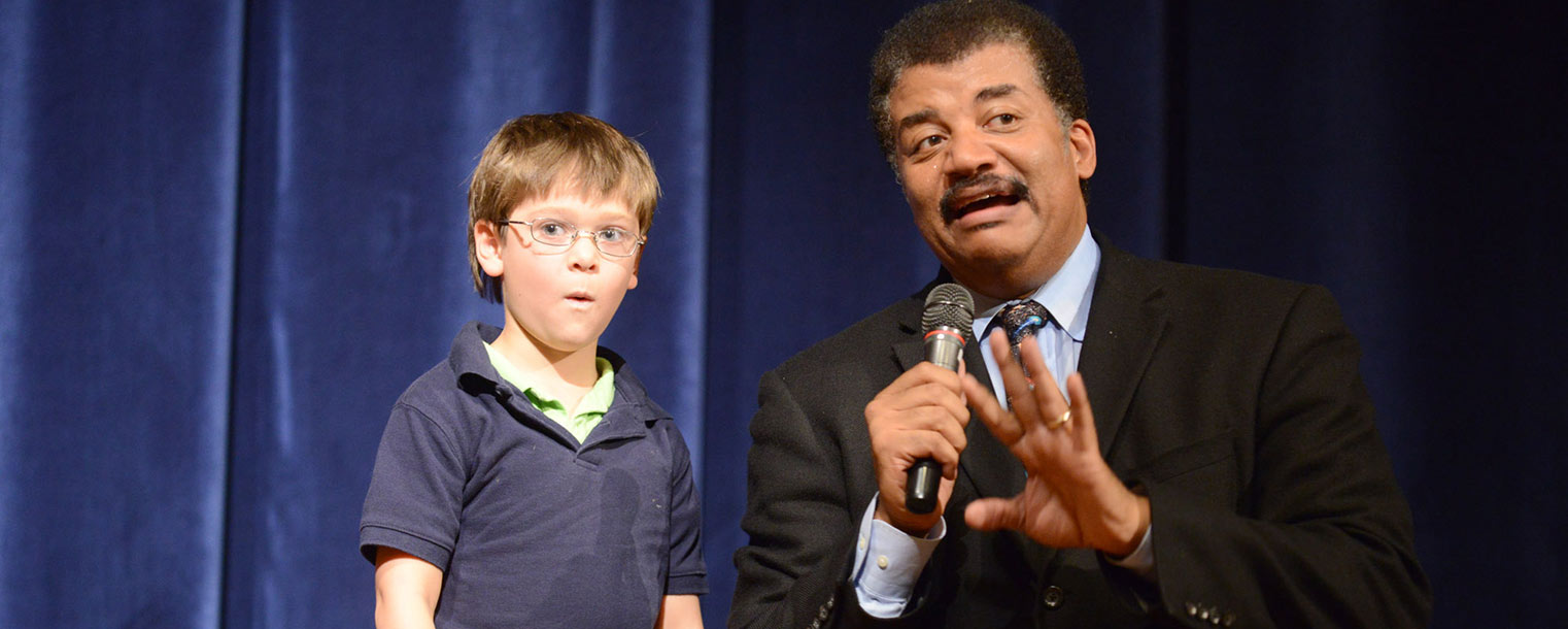 A young fan of Neil deGrasse Tyson looks stunned after Tyson carried him onto the stage to ask his question.