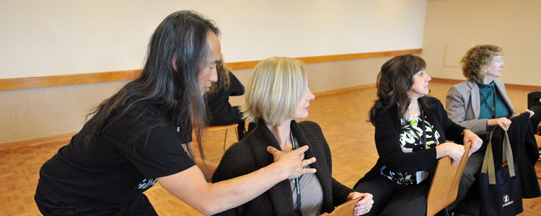 Rodney Yee,a well-known yoga expert and co-director of the Urban Zen Integrative Therapy Program, helps people do yoga poses during a workshop in the Kent Student Center.