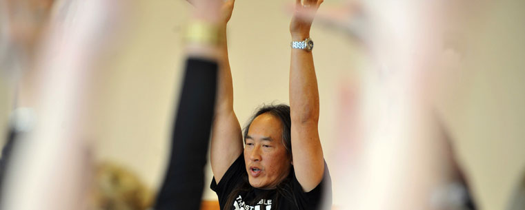 Rodney Yee, a well-known yoga expert and co-director of the Urban Zen Integrative Therapy Program, helps people do yoga poses during a workshop in the Kent Student Center.