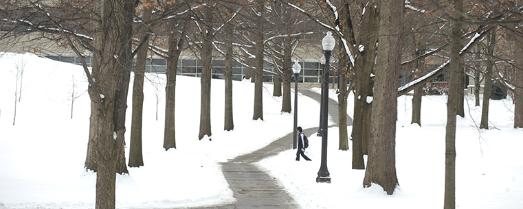 A Kent State student walks across the north part of campus on his way to class.