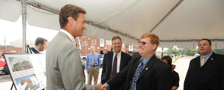 Karl Warnke, chairman, president and CEO of the Davey Tree Expert Company, shakes hands with Dan Smith, economic development director for the city of Kent.