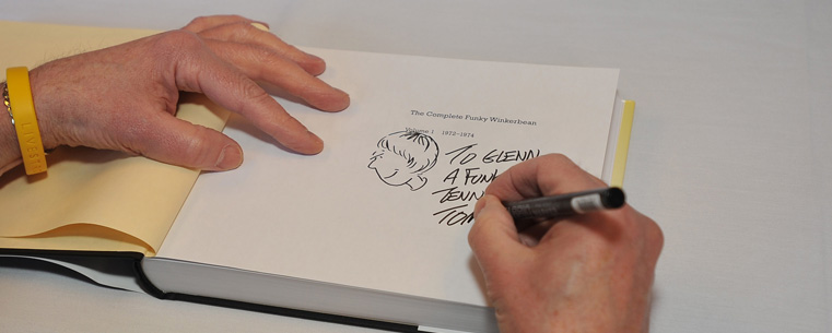 <p>Comic strip artist Tom Batiuk signs his autograph during the grand opening of The Nest in the Kent Student Center.</p>