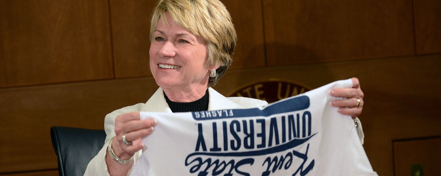 Kent State President Beverly Warren accepts a new Kent State T-shirt during a meeting with student media.