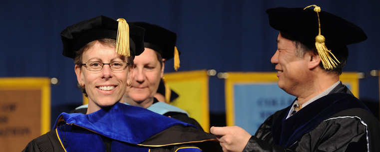 <p>A doctoral candidate is hooded during commencement ceremonies.</p>