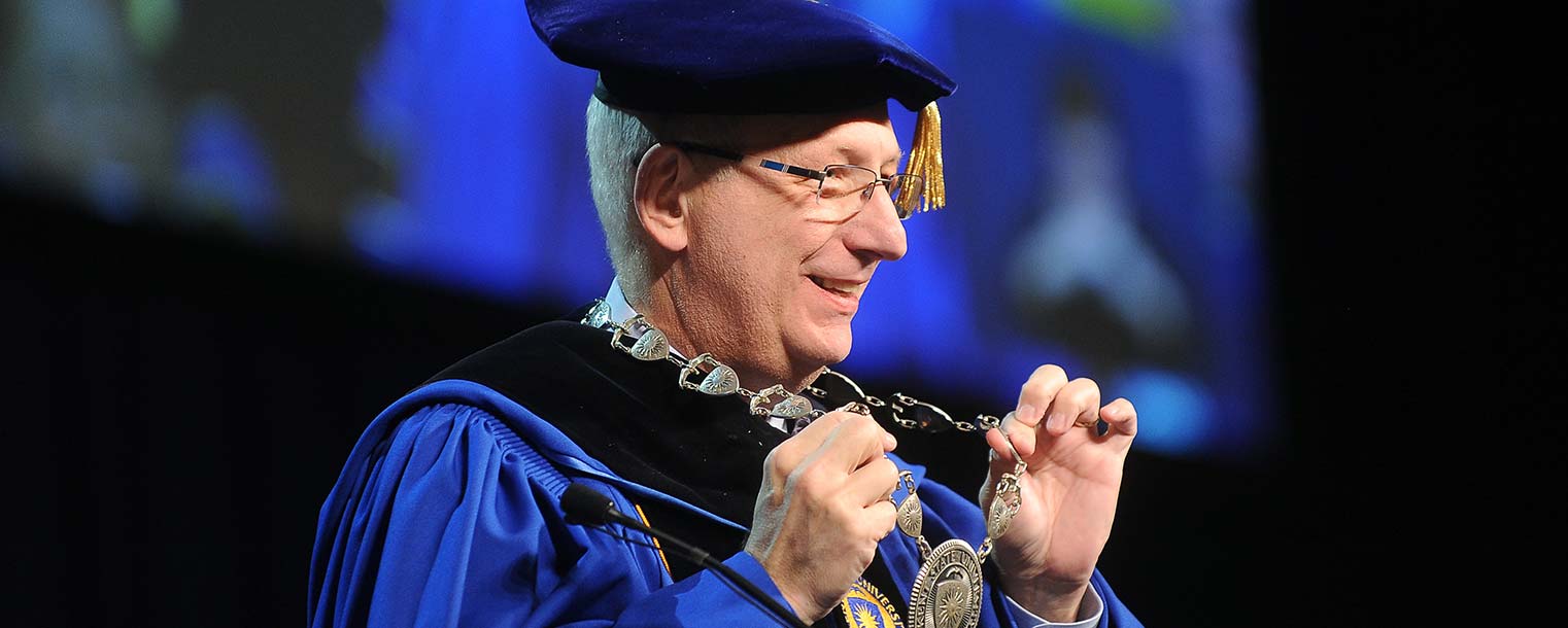 Kent State President Lester A. Lefton displays what he refers to as his "commencement bling" during the Dec. 13 Commencement ceremony.