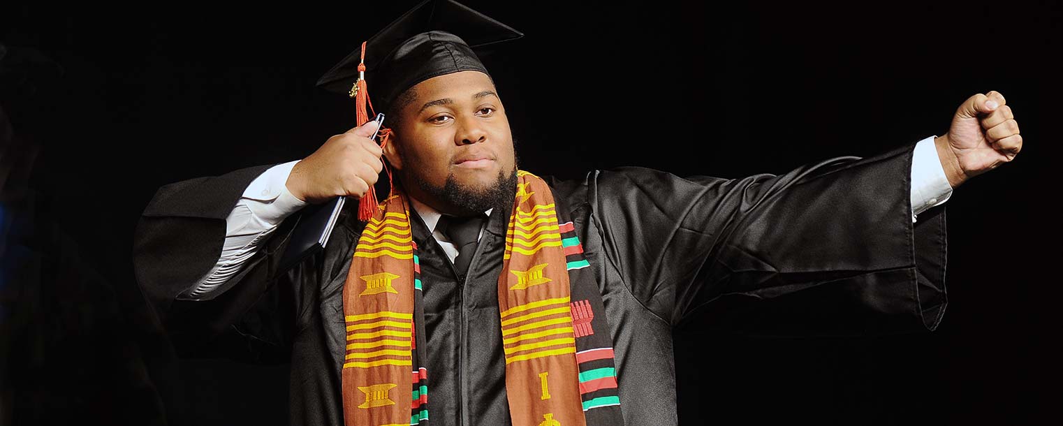 A proud 2013 Kent State graduate poses for photos for his family after receiving a diploma in the Memorial Athletic and Convocation Center.