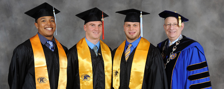 President Lester A. Lefton poses for photos with graduating members of the Kent State football team.<br />
<br />