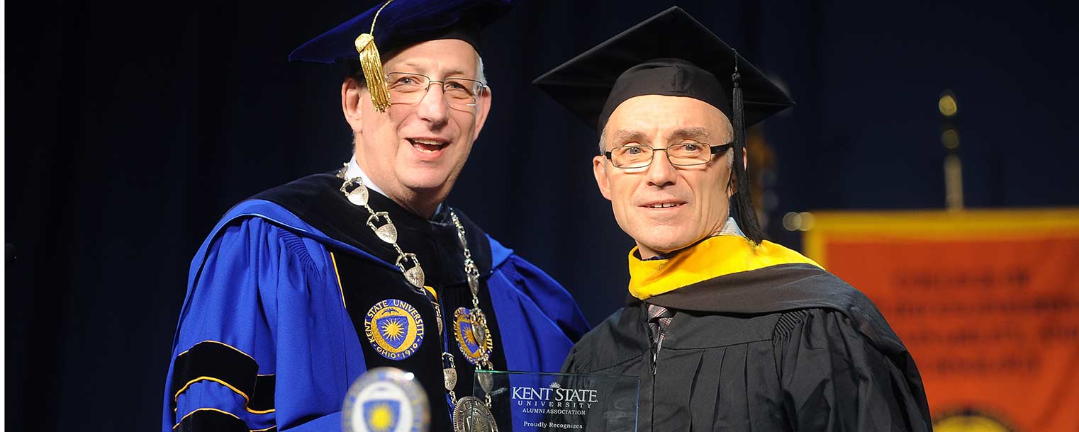 Kent State President Lester A. Lefton presents Commencement speaker Carl Walz with a distinguished alumni award during the Dec. 14 ceremony in the Memorial Athletic and Convocation Center.