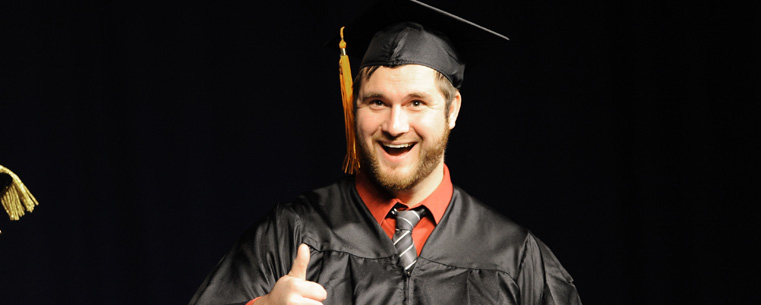 A graduating student flashes the "thumb's up" sign to his parents after receiving his diploma Saturday morning, in the Memorial Athletic and Convocation Center.