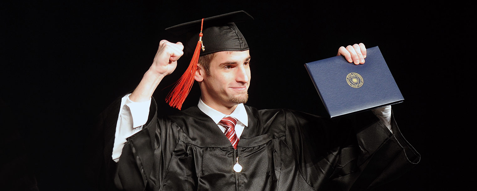 A proud Kent State graduate celebrates after receiving his diploma in the Memorial Athletic and Convocation Center.