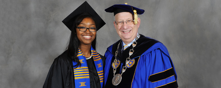 A Kent State graduate poses for a photograph with President Lester A. Lefton following commencement ceremonies in the Memorial Athletic and Convocation Center.