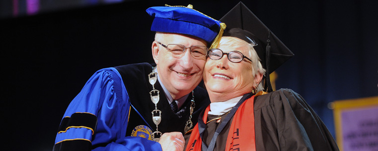 President Lefton embraces benefactor Roe Green after presenting her with the university medallion during commencement ceremonies.