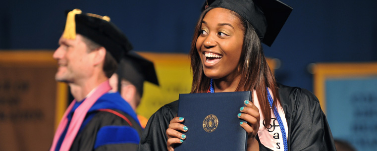 A Kent State graduate smiles in the direction of her family during commencement ceremonies Saturday morning.