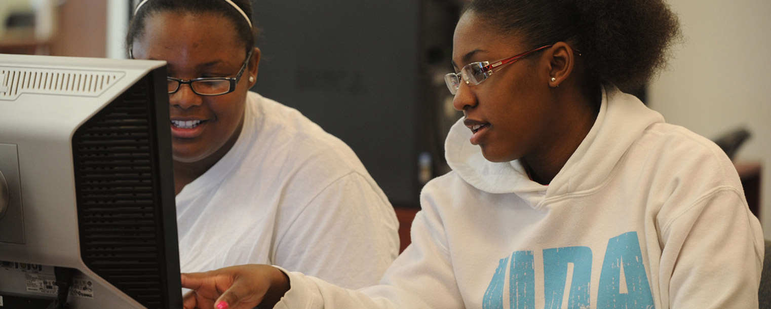 Kent State students review information on a computer in the library. For finals, the library is open 24 hours a day through May 9.