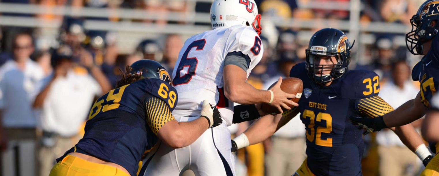 Kent State players Nate Terhune, defensive end, and Matt Dellinger, linebacker, tackle Liberty quarterback Josh Woodrum.