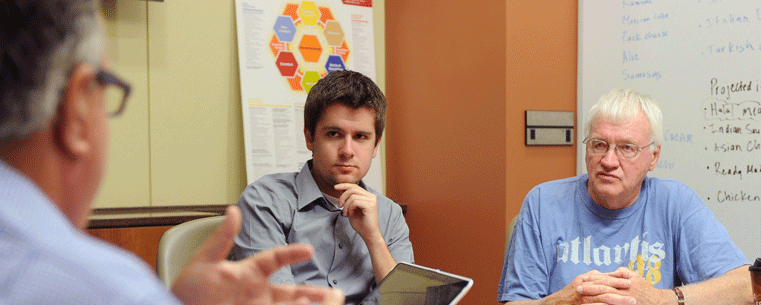 Entrepreneurs Lee McMannis (left) and Jack Burge (right) meet with Kent State University student Chris Lintner (center), an entrepreneur major and CEO of the campus-based laundry service Laundry in a Flash, to offer insight and advice.