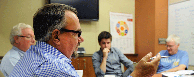 Entrepreneur Lee McMannis offers insight and advice to Kent State University student Chris Lintner (center). Also pictured are entrepreneurs Jack Burge (left background) and Mike Beder (far right).