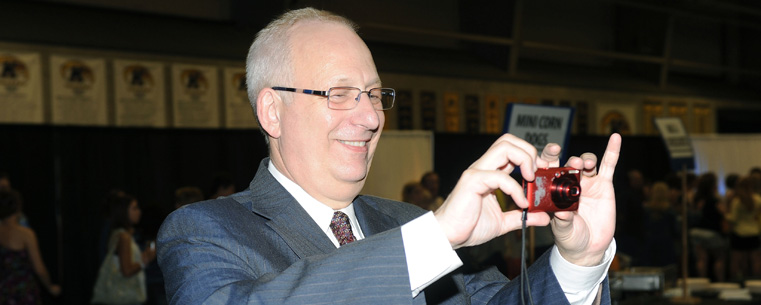 President Lester A. Lefton turns the tables on graduates at the Flashes Forever event, borrowing a student's camera to take a group photo.