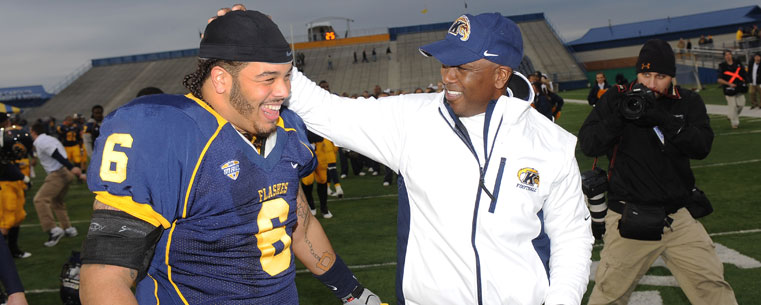 Head Coach Darrell Hazell congratulates defensive lineman Dana Brown Jr. following Kent State's 28-22 win over Eastern Michigan at Dix Stadium.